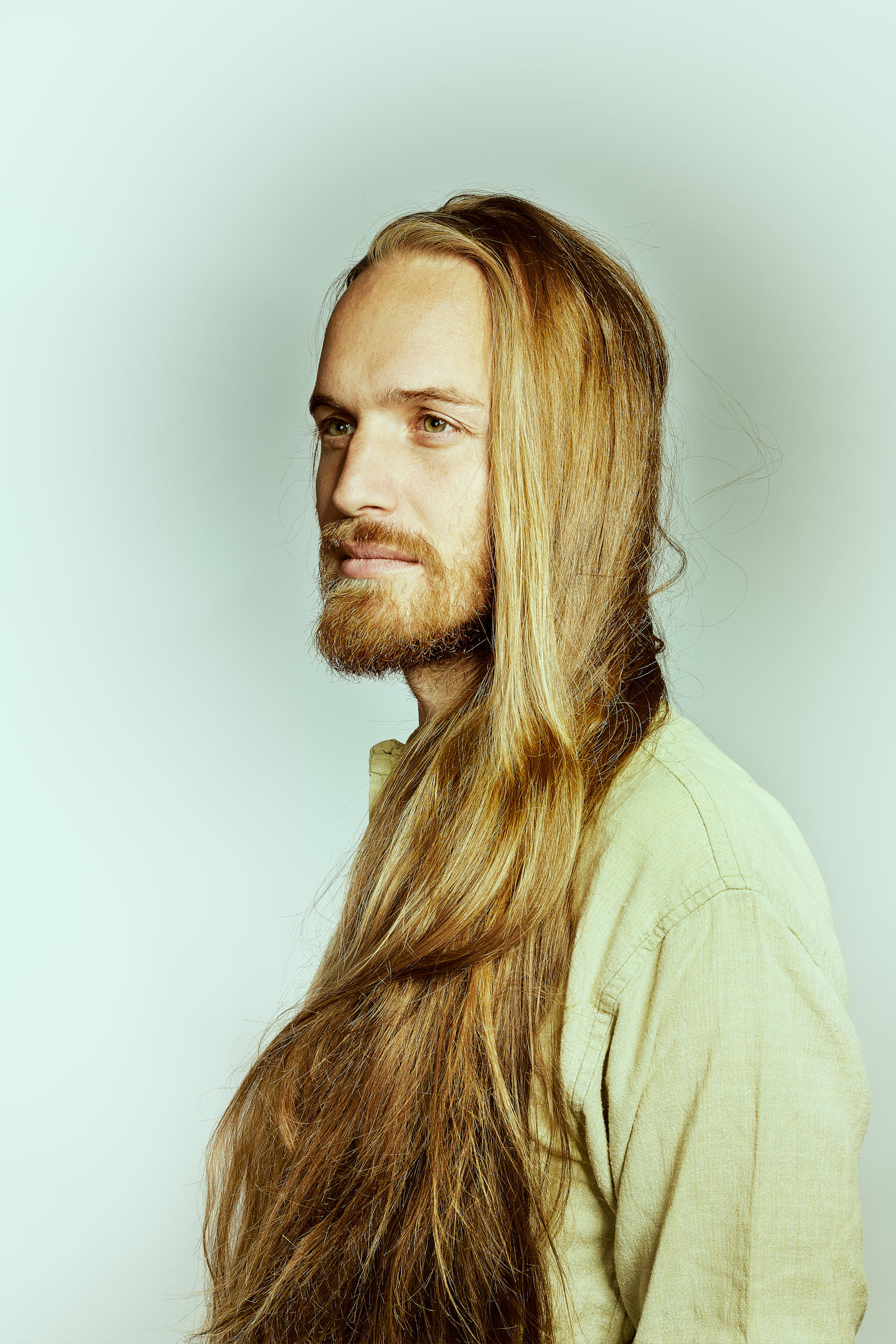 Classic portrait photography: Man with long hair in a studio setting.