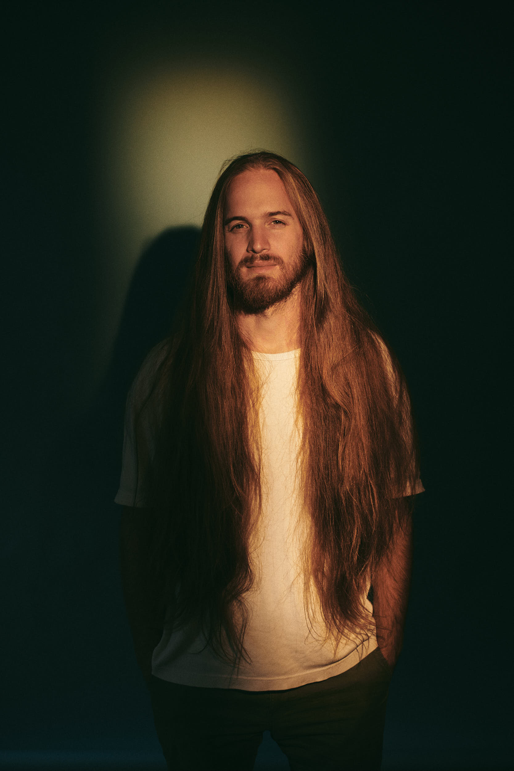 Classic portrait photography: Man with long hair in a studio setting.