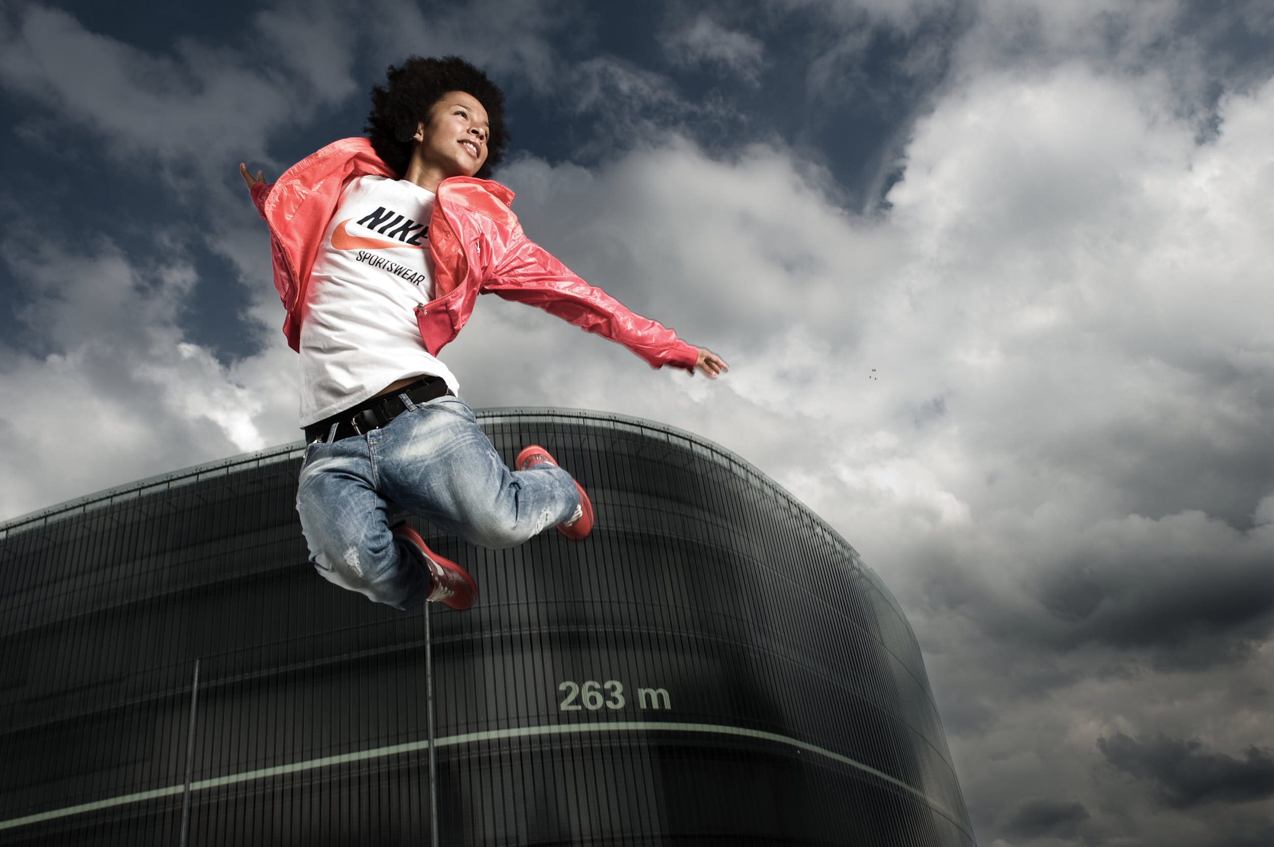 Dancer in sport apparel campaign jumping in front of a modern minimal architecture.