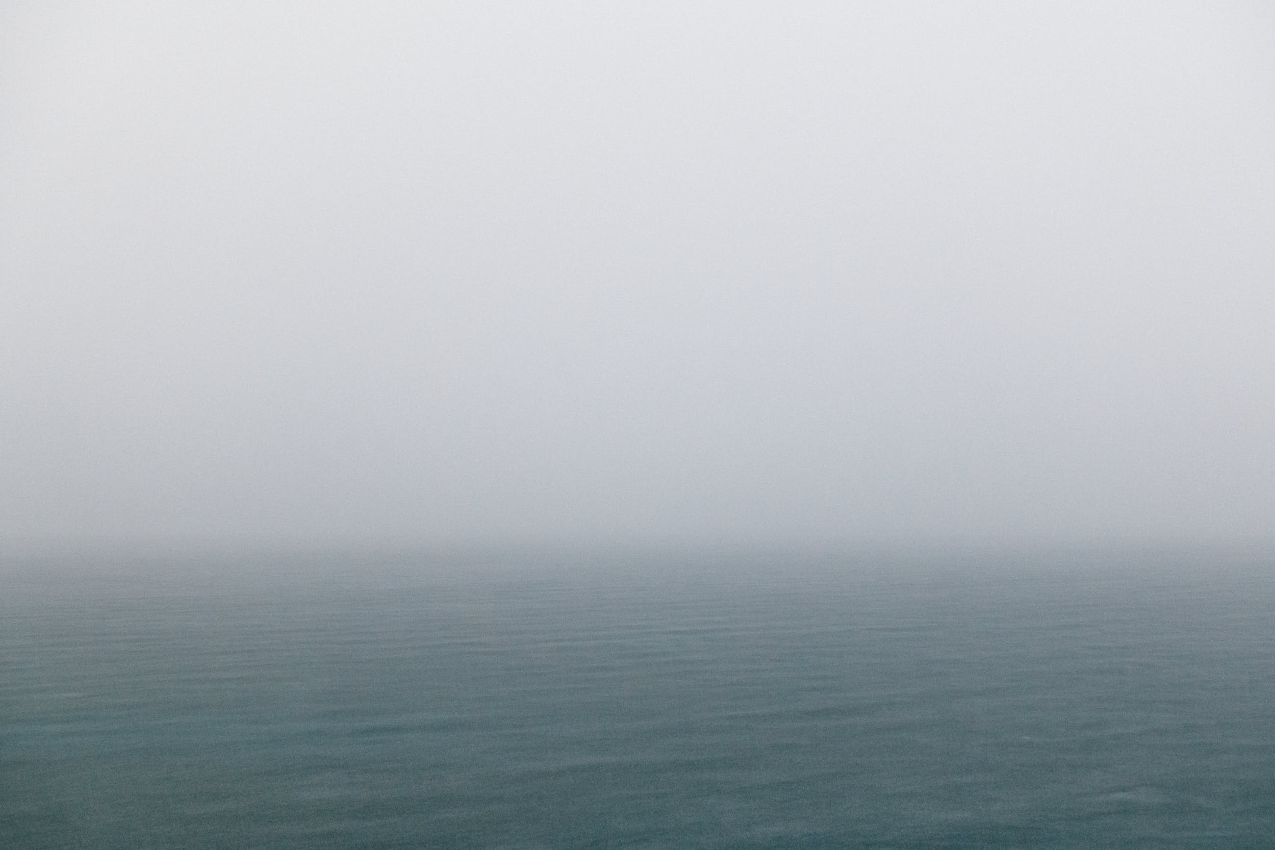 Dramatic minimal seascape during a storm with cool and muted colors.