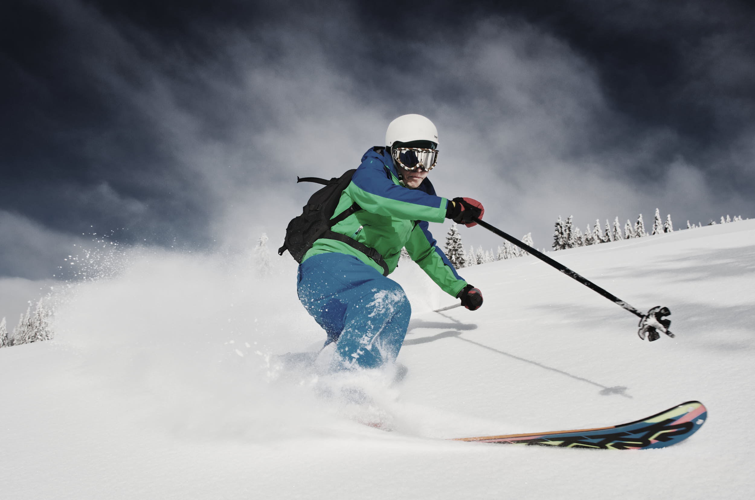 Freeride telemark skier making a turn in fresh powder snow.