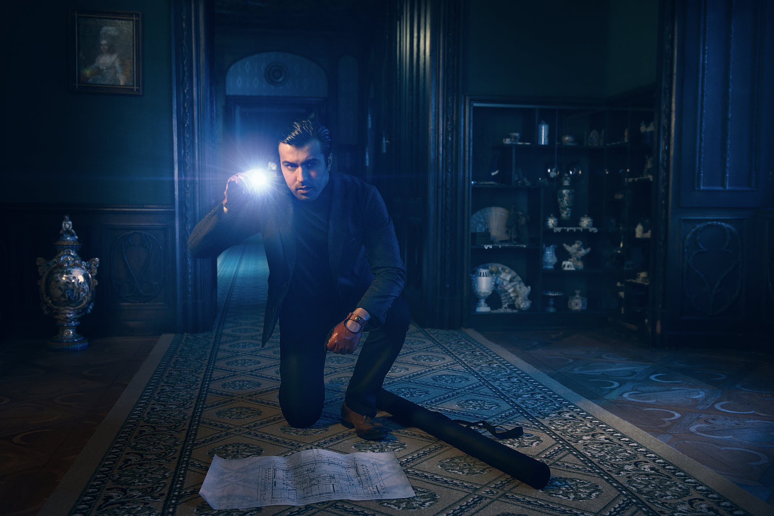 Cinematic editorial photography: a thief with a flashlight is preparing to rob a castle.