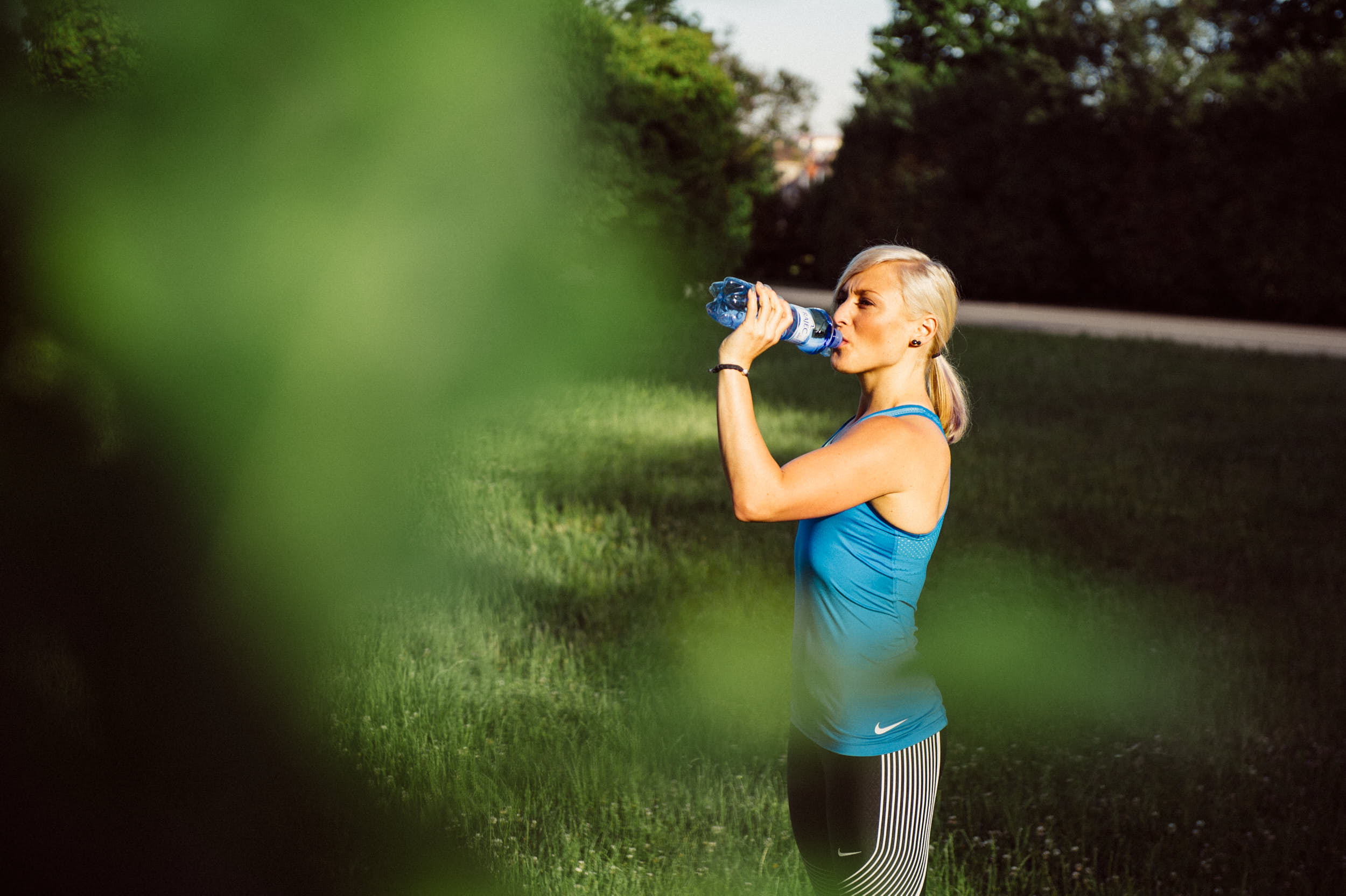 Active lifestyle photography: girl drinking from a water bottle after a workout.