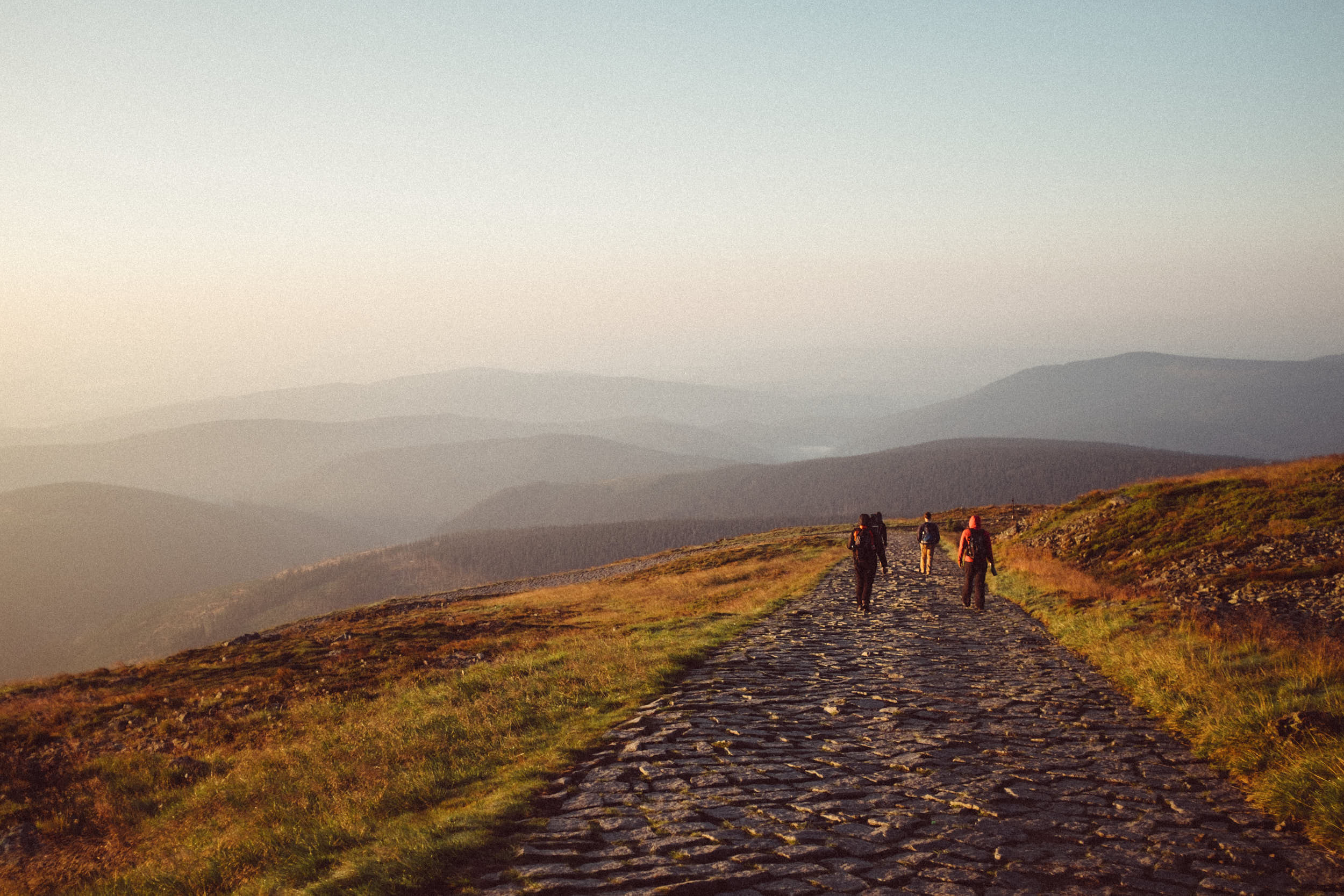 Beautiful travel photography: group of hikers descending a mountain at dawn.