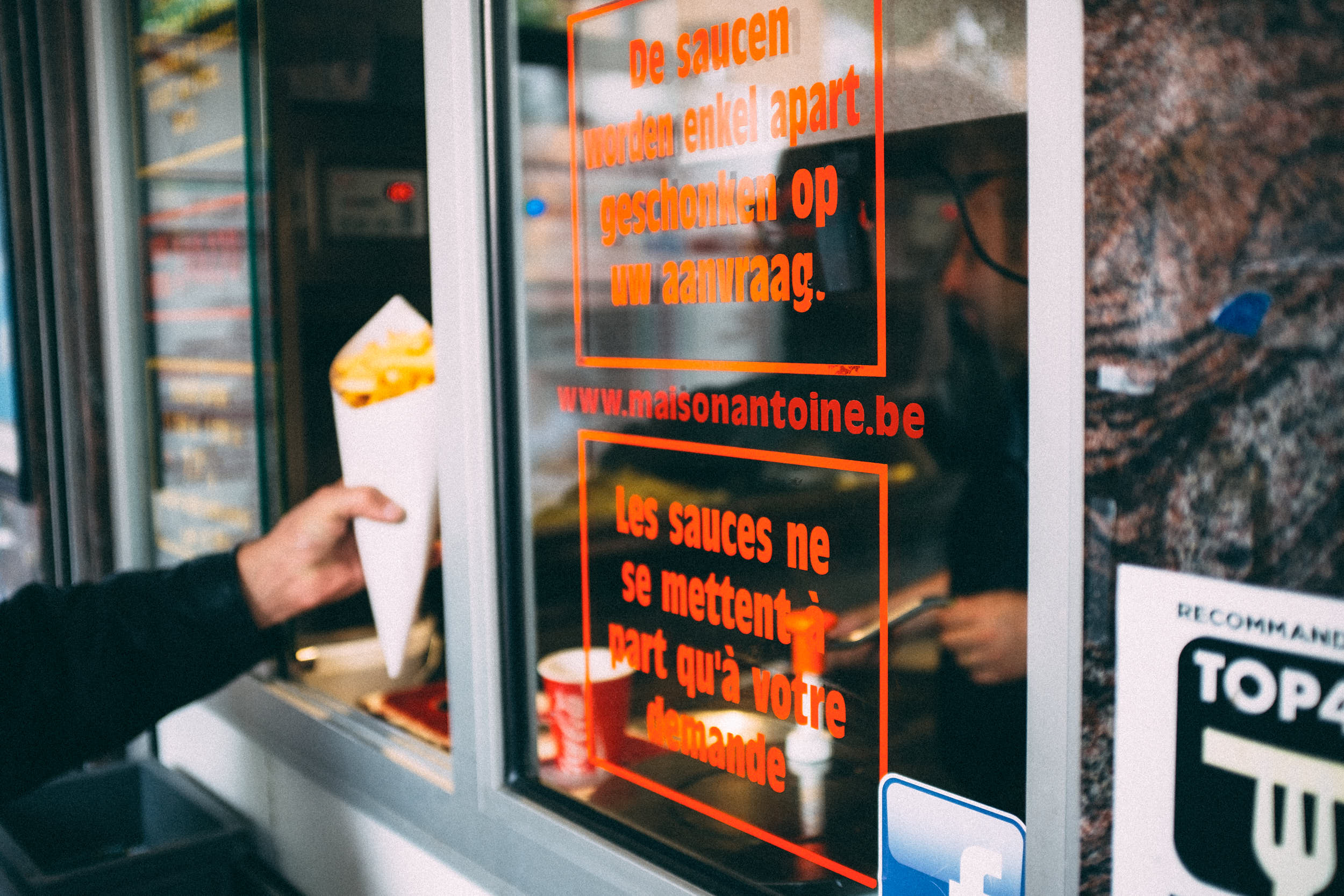 Man buying french fries on a street food market in Brussels.