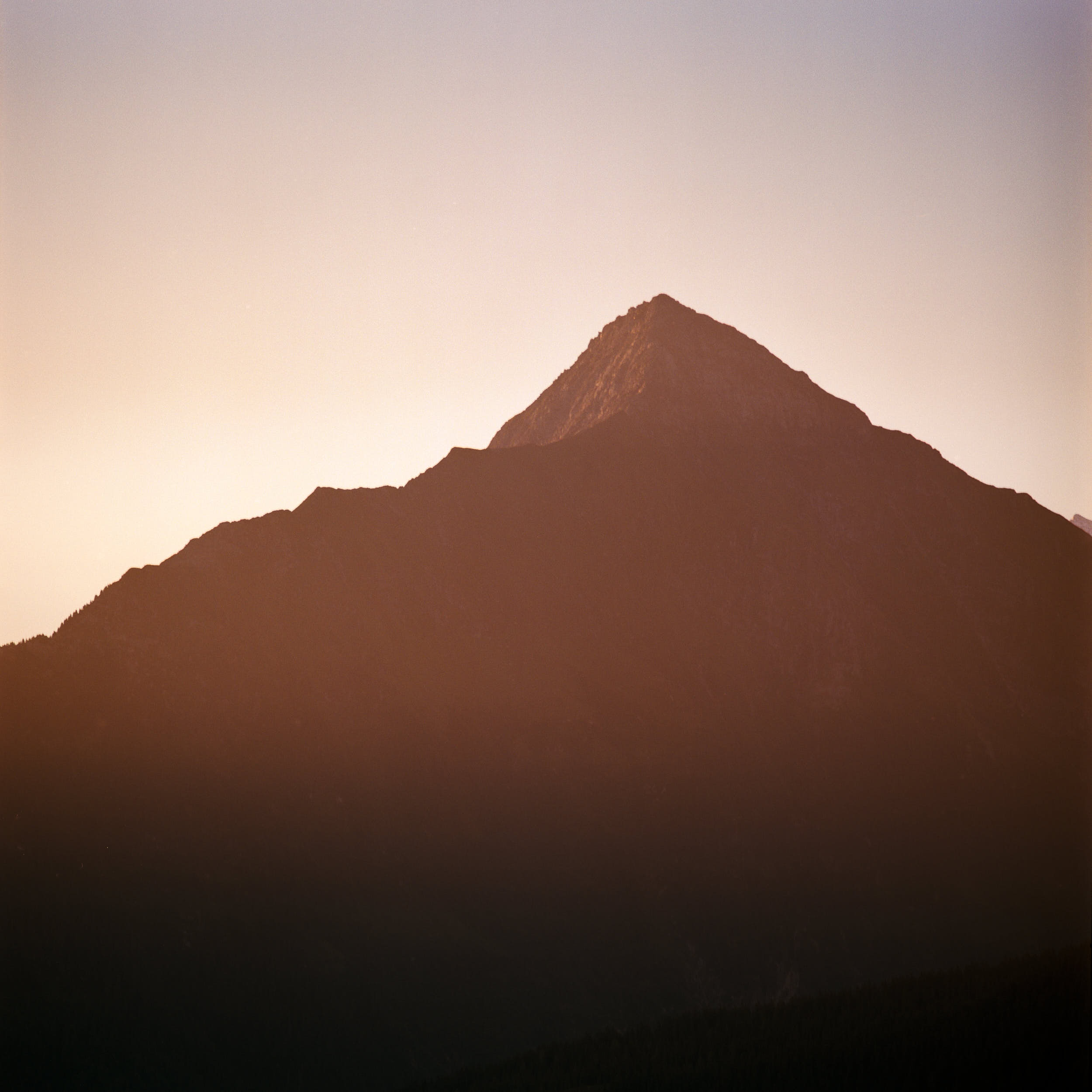 First sunlight hitting the top of alpine peaks. Shot on medium format color film.