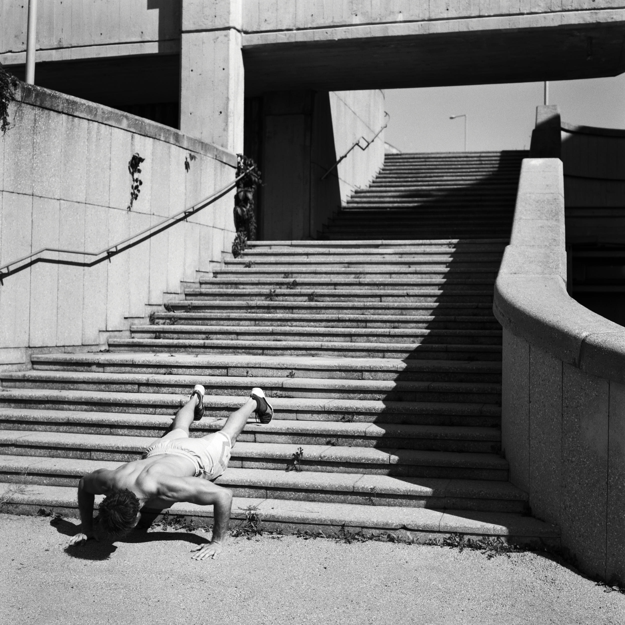 Crossfit athlete doing push ups on a concrete staircase.